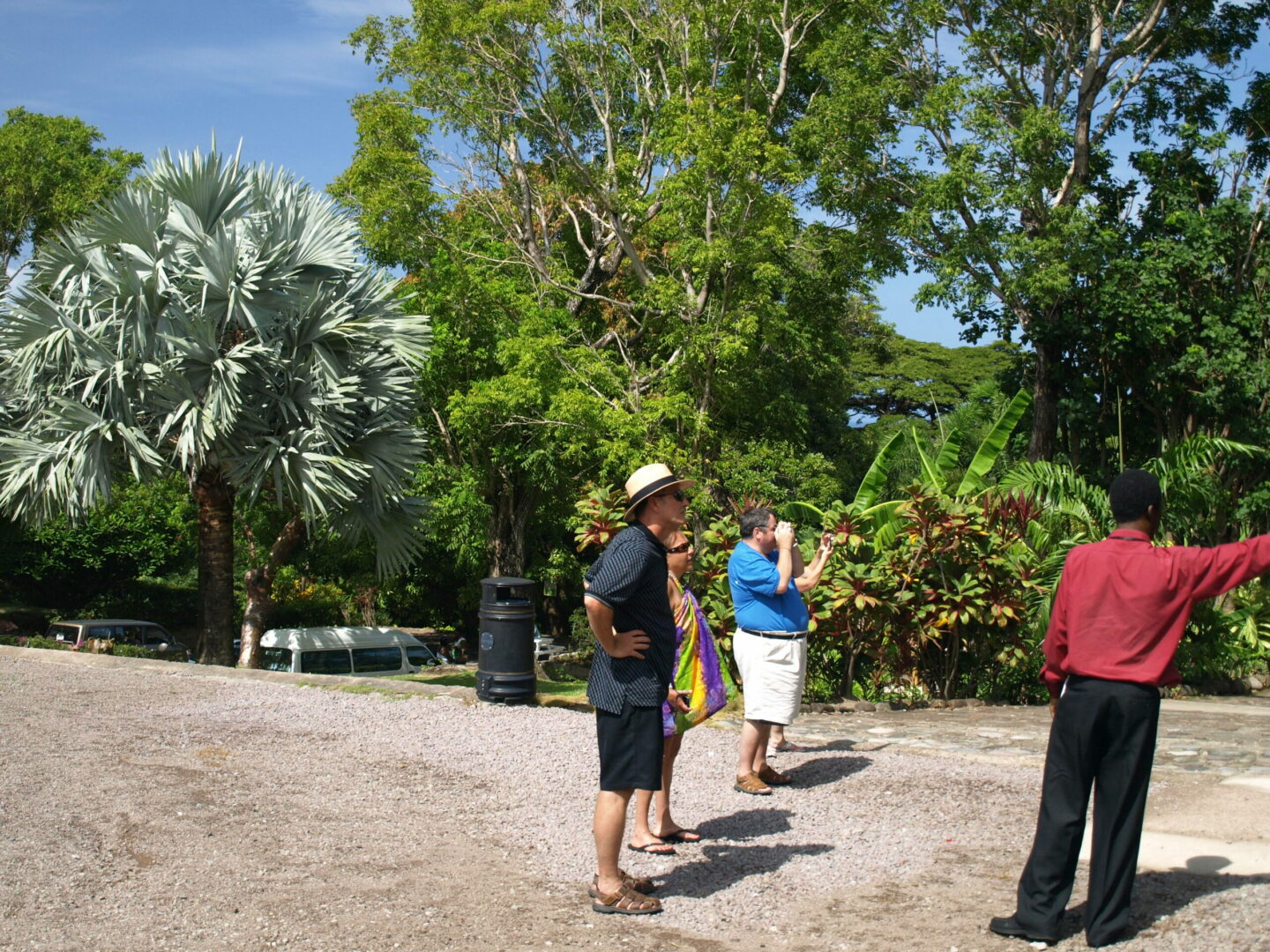 A group of people standing on top of a dirt road.